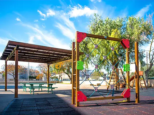 Patio del CP Es Canyar con pérgola de madera y estructura para trepar
