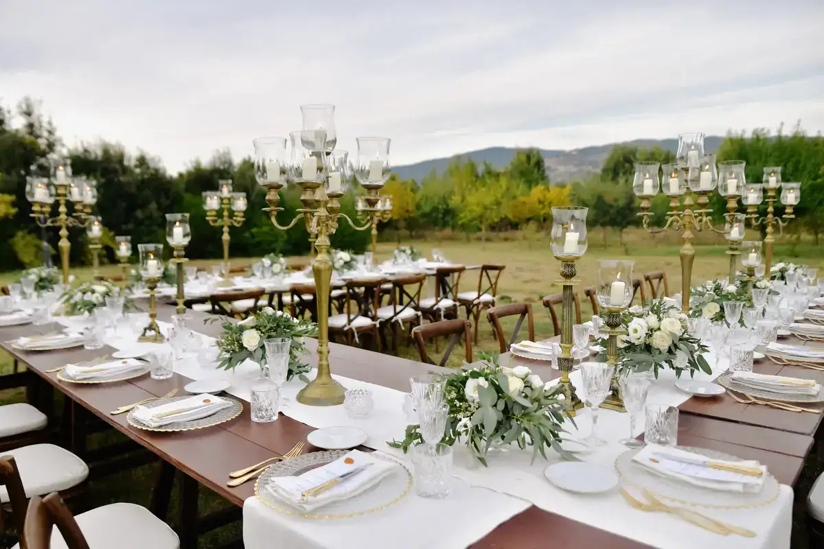Mesa de boda decorada al aire libre en un jardín con montañas al fondo